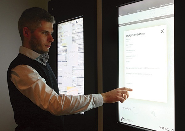 Jakub Zorzycki szuka znajomego nazwiska zesłańca na dotykowym ekranie