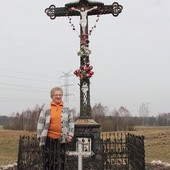 Elżbieta Sychowska pod krzyżem, który ufundowała rodzina z okazji I Komunii św. jednej z córek. Od tamtego czasu stał się miejscem wspólnej modlitwy w czasie okolicznościowych nabożeństw