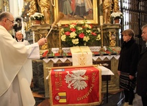 Ks. Wiesław Skonieczny święci sztandar łowickiego koła pszczelarzy. Obok Agnieszka Krajewska i Krzysztof Jan Kaliński