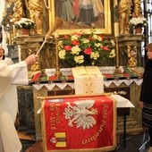 Ks. Wiesław Skonieczny święci sztandar łowickiego koła pszczelarzy. Obok Agnieszka Krajewska i Krzysztof Jan Kaliński