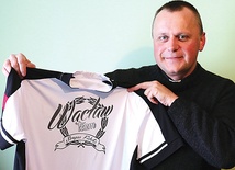  Ks. Piotr Zamaria z koszulką, na której widnieje logo grupy