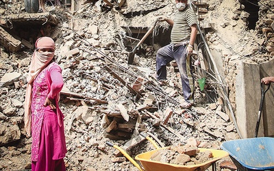 Zniszczona w 90 proc. miejscowość Bungamati. Mieszkańcy zburzonego domu biorą udział w odgruzowywaniu ruin 