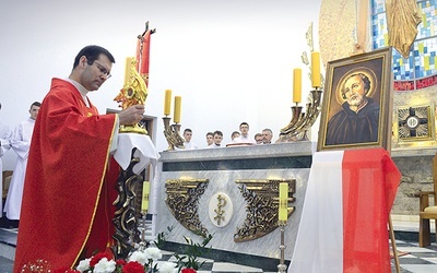  Relikwiarz obok portretu świętego ustawia proboszcz ks. Andrzej Jędrzejewski