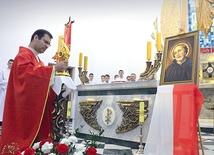  Relikwiarz obok portretu świętego ustawia proboszcz ks. Andrzej Jędrzejewski