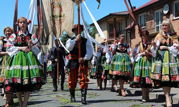 Procesja przebiega drogą usłaną tatarakiem