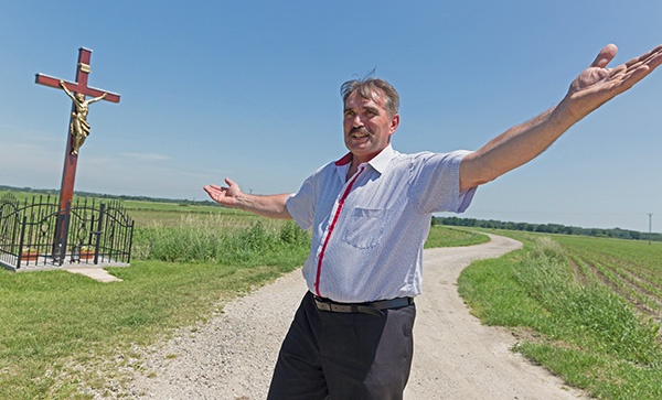 Sołtys Tadeusz Wójcik przy nowym krzyżu upamiętniającym ofiary wojny. Poprzedni został rozdarty na pół przez piorun, który uderzył w środku słonecznego dnia