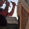 Pan Kazimierz rzeźbi Michała Archanioła trzymającego w dłoniach miecz