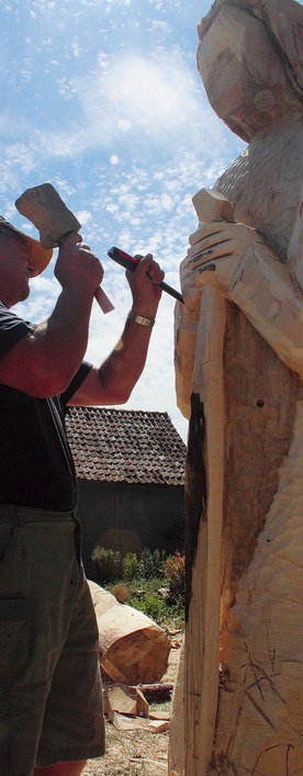 Pan Kazimierz rzeźbi Michała Archanioła trzymającego w dłoniach miecz