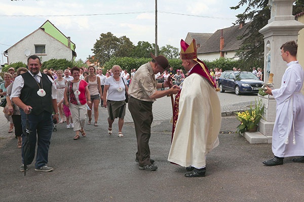 Bp Rudolf Pierskała wita przed kościołem przewodnika z pielgrzymami