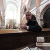 Ks. Piotr Nowak ze znaczkiem promującym tumską archikolegiate