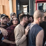 Z wyspy Lesbos płyną promami w stronę Europy głównie mężczyźni – samotni i młodzi. Syryjczycy, Irakijczycy, Irańczycy, Afgańczycy, Pakistańczycy, a nawet Hindusi i Somalijczycy. Kiedy podpływa prom, kobiety i dzieci jakby giną w męskim tłumie. W trakcie przepychanek przy kasach biletowych spotkałem młodego Syryjczyka. Pierwszą osobę, która przyznała, że uciekła przed ISIS. Nie pozwolił zamieścić swego zdjęcia. Hipsterski look. Eleganckie okrągłe oprawki od okularów, lekki zarost, modne i dobrze zestawio...