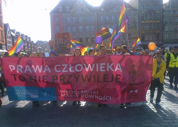 Tęczowy pochód na transparentach