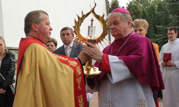 Ks. Marian Kulik podaje biskupowi Tadeuszowi Rakoczemu do uczczenia relikiwe św. Faustyny