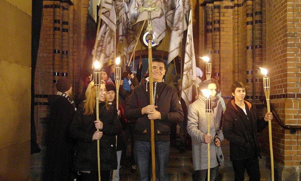 Z krzyżem, relikwiami i flagami