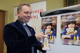 Do zapalenia świecy Caritas na wigilijnym stole zachęca ks. Robert Kowalski