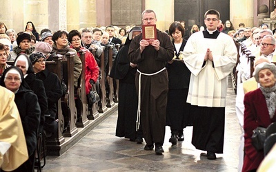 Przedstawiciele zakonów niosą w procesji do ołtarza księgę uchwał  43. Synodu Diecezji Płockiej