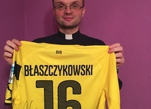 Ksiądz Krzysztof Misiuda z koszulką Kuby Błaszczykowskiego na licytację
