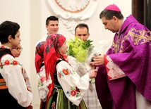 Bp Wojciech Osial przyjmuje kwiaty od dzieci ze Szkoły Podstawowej w Zielkowicach
