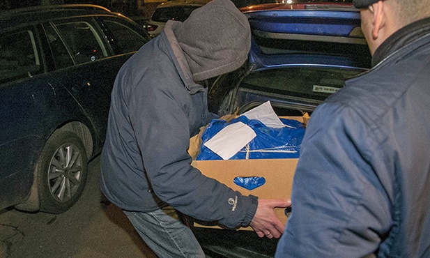 Funkcjonariusze policji wynoszą dokumentację znalezioną podczas przeszukania domu gen. Czesława Kiszczaka