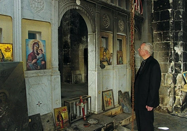 Abp Stanisław Gądecki w spalonym kościele w Malula