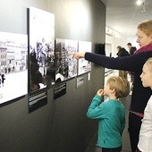  Najmłodsi patrzą na zdjęcia zbombardowanej Warszawy z niedowierzaniem