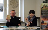 Ks. Piotr Nowak i Aneta Jeziorska przentują sakwę tumską i krzyż św. Wojciecha przygotowane dla uczestników wydarzenia