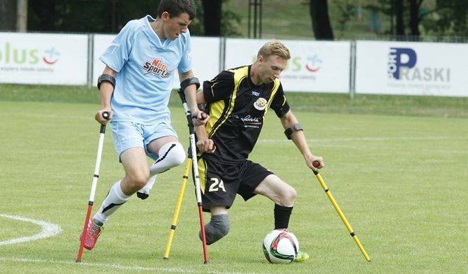 W amp futbolu zawodnicy kopią piłkę zdrową nogą 