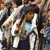 Jemeński chłopak z bronią obok grupy wspierającej szyickich rebeliantów Huti, kontrolujących Sanę oraz terytoria na północy i zachodzie kraju. 21.04.2016 Jemen. Sana.