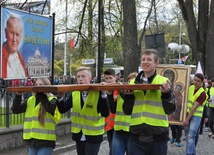 Procesja ze znakami. W tle obraz św. Jana Pawła II, patrona Światowych Dni Młodzieży
