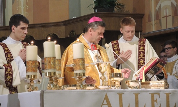 Z bp. Romanem Pindlem przy ołtarzu przedstawiciele nowych diakonów - dk. Tymoteuz Szydło (z lewej) i dk. Michał Marek