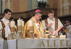 Z bp. Romanem Pindlem przy ołtarzu przedstawiciele nowych diakonów - dk. Tymoteuz Szydło (z lewej) i dk. Michał Marek