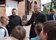 Biskup Wiesław Szlachetka w czasie rozmowy z najmłodszymi uczestnikami spotkania w Trąbkach Wielkich