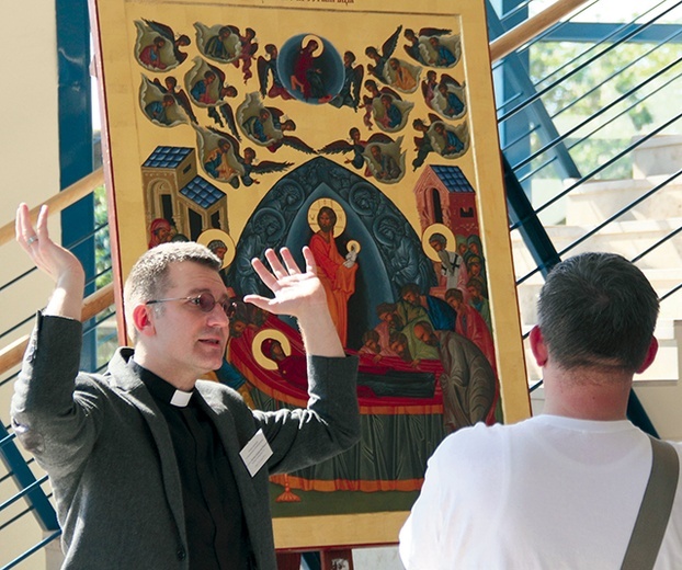 Ksiądz Dariusz  Klejnowski-Różycki oprowadza po wystawie ikon, która towarzyszyła konferencji.