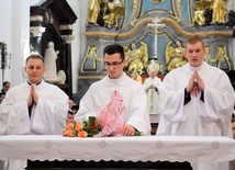 Nowo wyświęceni kapłani składają kwiaty na ołtarzu, jako wyraz wdzięczności Bogu za dar powołania