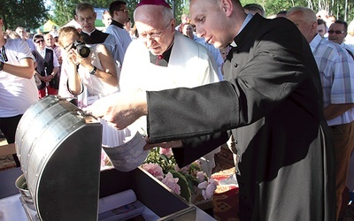 Bp Andrzej F. Dziuba i ks. Rafał Babicki zaglądają do metalowej skrzyni.