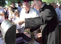 Bp Andrzej F. Dziuba i ks. Rafał Babicki zaglądają do metalowej skrzyni.