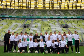 Pamiątkowe zdjęcie młodych piłkarzy z abp. Sławojem Leszkiem Głódziem na stadionie Energa