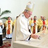 Arcybiskup Stanisław Budzik wylewa na ołtarz olej w celu namaszczenia.
