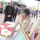 Danuta Ciesielska symbolicznie wbija gwóźdź w drzewce sztandaru szkoły.