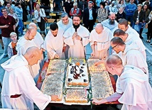 Trudno było zapalić wszystkie świeczki przy wietrze,  ale zdmuchnięcie nie stanowiło już problemu dla zakonników w białych habitach.
