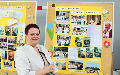 Dyrektor Anna Walusiak przy wystawie szkolnych zdjęć z patronem.