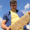 Ks. Tomasz Gałuszka prezentuje pierwszy plaster miodu wyprodukowany przez "kulowskie" pszczoły.