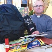 Ks. Marcin Płaneta z Dębicy-Latoszyna prezentuje zawartość wypełnionych plecaków.