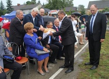 Włodarze gminy dzielili się chlebem z obecnymi na dożynkach. Z prawej wójt Marian Kmiecik