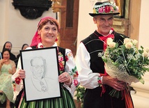 Starostowie dożynek z portretem ks. Wiesława Skoniecznego.