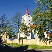 Kościół parafialny otoczony nowym  ogrodzeniem. 