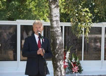 Krzysztof Jan Kaliński, burmistrz Łowicza, przed tablicami z nazwiskami pochowanych żołnierzy