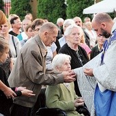 ▲	Ks. Krzysztof Osiński całuje krzyż pielgrzymkowy jednej z wiosek swojej parafii. 