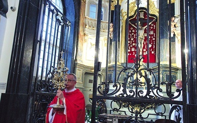 Proboszcz katedry błogosławi relikwiarzem z cząstką Drzewa Krzyża Świętego.