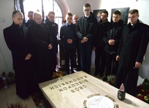 Alumni w kaplicy cmentarnej przed płytą nagrobną biskupów Edwarda Materskiego i Stefana Siczka